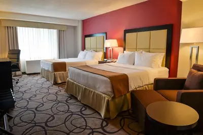 a hotel room with two beds and a couch at Holiday Inn Montreal Centre Ville Downtown by IHG in Montréal