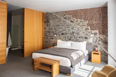 a bedroom with a bed and a brick wall at Hotel Gault in Montréal