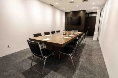 a conference room with a long wooden table and chairs at Hotel Gault in Montréal