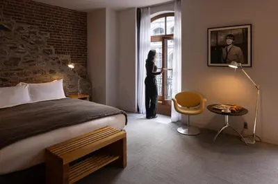 a woman standing in a hotel room looking out the window at Hotel Gault in Montréal
