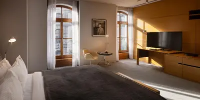 a bedroom with a large bed and a flat screen tv at Hotel Gault in Montréal
