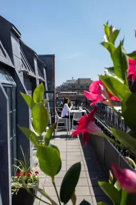 a woman sitting at a table on a balcony at Hotel Gault in Montréal