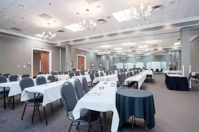 a banquet hall with white tables and chairs at Sandman Hotel Montreal - Longueuil in Longueuil