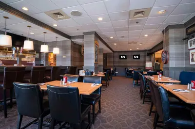 a dining room with wooden tables and chairs at Sandman Hotel Montreal - Longueuil in Longueuil