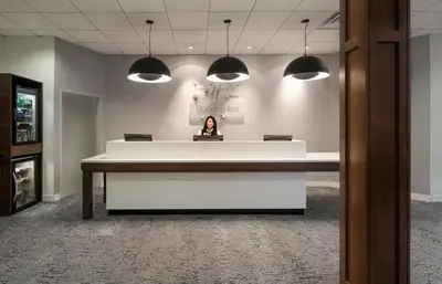 a woman sitting at a desk in an office at Holiday Inn Montreal Longueuil by IHG in Longueuil