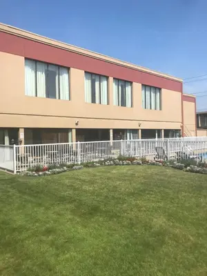 a building with a white fence in front of a yard at Auberge Royal Versailles in Montréal