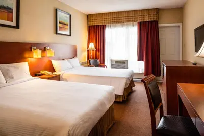 a hotel room with two beds and a desk at Auberge Royal Versailles in Montréal