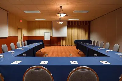 a large conference room with a blue table and chairs at Auberge Royal Versailles in Montréal