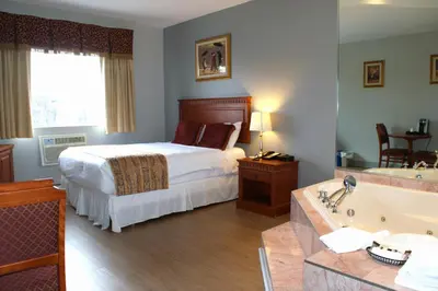a hotel room with a bed and a bath tub at Auberge Royal Versailles in Montréal