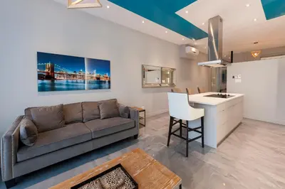a living room with a couch and a kitchen at Boutique Lofts Milton Parc by Simplissimmo in Montréal