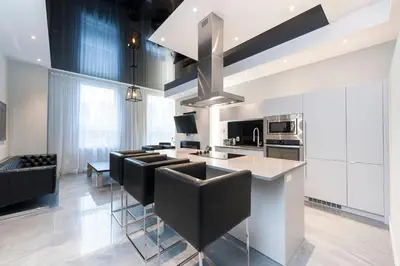 a kitchen with black chairs and a kitchen island at Boutique Lofts Milton Parc by Simplissimmo in Montréal