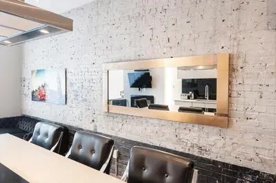 a dining room with a mirror on a brick wall at Boutique Lofts Milton Parc by Simplissimmo in Montréal