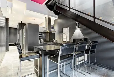 a kitchen with a black table and chairs at Boutique Lofts Milton Parc by Simplissimmo in Montréal