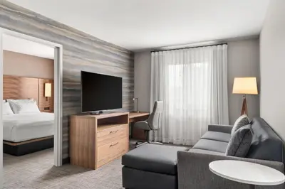 a hotel room with a couch and a tv and a bed at Residence Inn by Marriott Laval in Laval