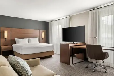 a hotel room with a bed and a desk with a television at Residence Inn by Marriott Laval in Laval