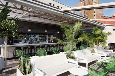 a patio with white chairs and a bar at William Gray by Gray Collection in Montréal
