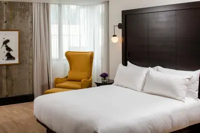 a bedroom with a large bed and a chair at William Gray by Gray Collection in Montréal