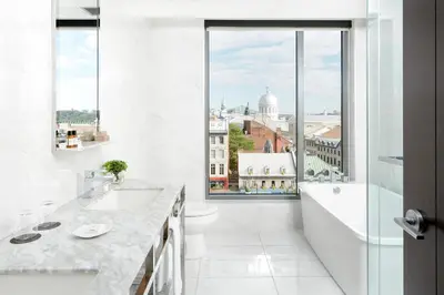 a white bathroom with a view of a city at William Gray by Gray Collection in Montréal