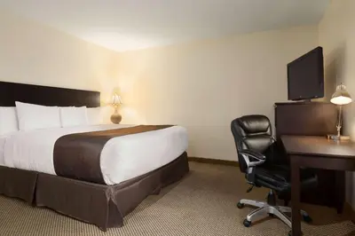 a hotel room with a bed and a desk and a computer at Days Inn by Wyndham Trois-Rivieres in Trois-Rivières