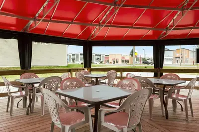 a row of tables and chairs on a patio at Days Inn by Wyndham Trois-Rivieres in Trois-Rivières