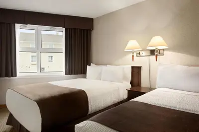 a hotel room with two beds and a window at Days Inn by Wyndham Trois-Rivieres in Trois-Rivières