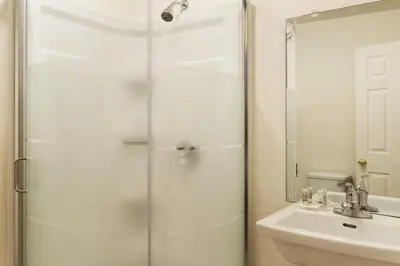 a bathroom with a glass shower and a sink at Days Inn by Wyndham Trois-Rivieres in Trois-Rivières