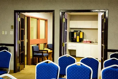 a waiting room with blue chairs and a kitchen at Days Inn by Wyndham Trois-Rivieres in Trois-Rivières