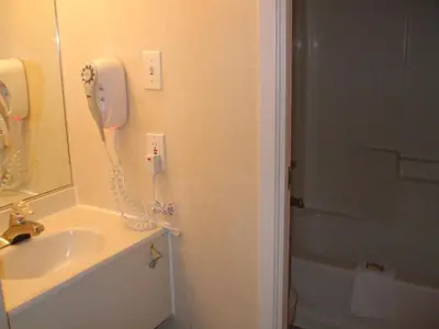 a bathroom with a phone on the wall next to a sink at Days Inn by Wyndham Trois-Rivieres in Trois-Rivières