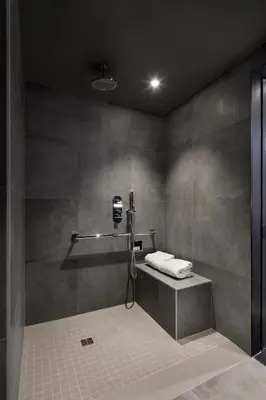 a bathroom with a shower with a camera on the wall at Hotel Monville in Montréal