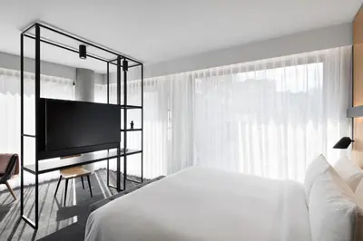 a bedroom with a bed and a flat screen tv at Hotel Monville in Montréal