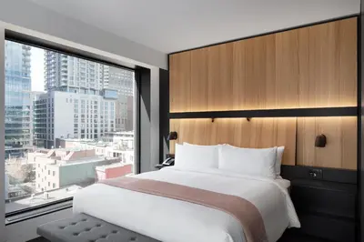 a bedroom with a large bed and a large window at Hotel Monville in Montréal