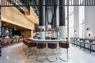 a bar with stools and a counter in a building at Hotel Monville in Montréal