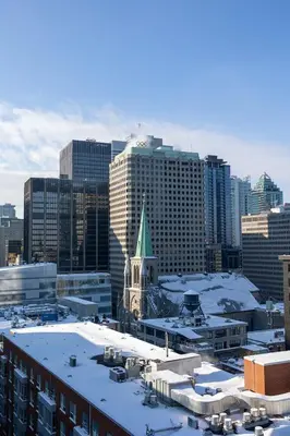 a building with a green steeple in a city at Hotel Monville in Montréal