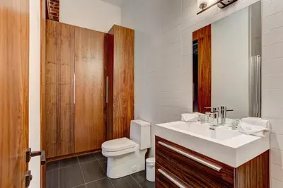 a bathroom with a white sink and a toilet at Le Merrill - Vieux Montréal in Montréal