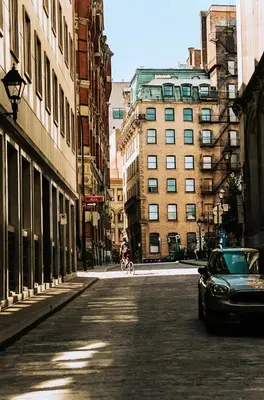 a person riding a bike down a city street at Le Merrill - Vieux Montréal in Montréal