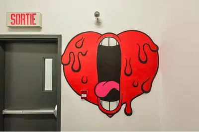 a heart shaped sign on the wall of a bathroom at Le Merrill - Vieux Montréal in Montréal