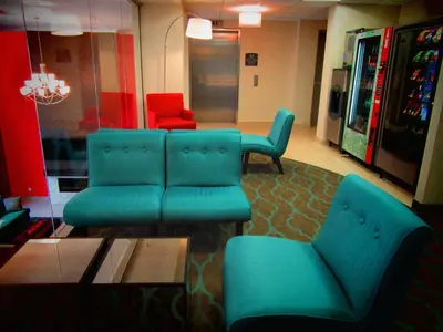 a living room with blue furniture and red chairs at Best Western Plus Hotel Montreal in Montréal