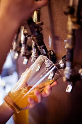 a person is holding a drink in a glass at Auberge Sutton Brouerie in Sutton