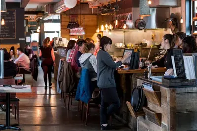 a group of people standing at a counter in a restaurant at Auberge Sutton Brouerie in Sutton