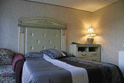 a bedroom with a bed and a lamp and a dresser at Motel Bellevue in Saint-Joseph-de-Beauce