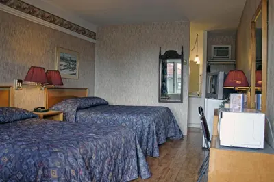 a hotel room with two beds and a refrigerator at Motel Bellevue in Saint-Joseph-de-Beauce