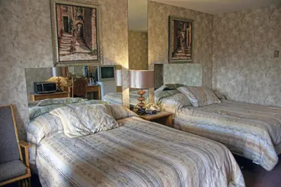 a hotel room with two beds and a television at Motel Bellevue in Saint-Joseph-de-Beauce