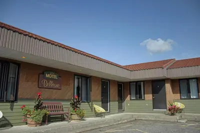 a building with a bench and a sign on it at Motel Bellevue in Saint-Joseph-de-Beauce