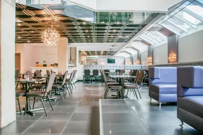 a dining room with tables and chairs and windows at Empire Suites in Montréal