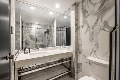 a bathroom with a sink and a toilet and a mirror at Empire Suites in Montréal