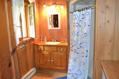 a bathroom with a sink and a shower curtain at Aux Retrouvailles spa à l'année in Lac-Mégantic