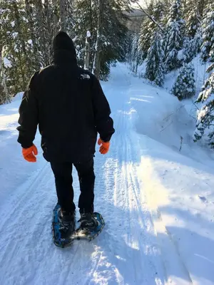 a man riding a snowboard down a snow covered path at Aux Retrouvailles spa à l'année in Lac-Mégantic
