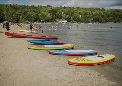 a group of kayaks lined up on the beach at Aux Retrouvailles spa à l'année in Lac-Mégantic