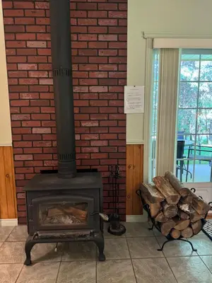 a fireplace with a pile of logs next to a brick wall at Havre De Paix in Piopolis