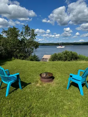 two blue chairs and a fire pit in the grass at Havre De Paix in Piopolis